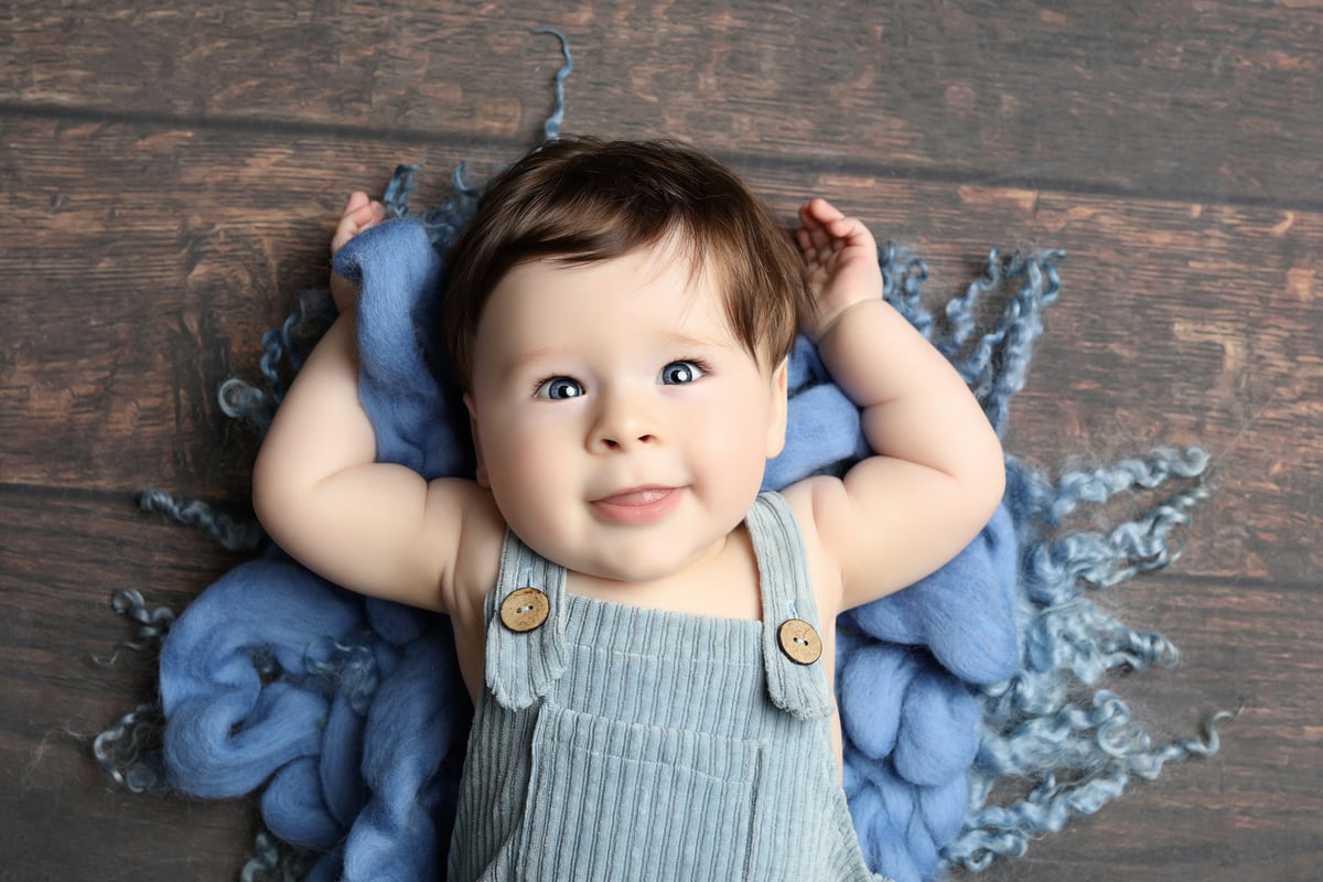 baby laying down on a blue blanket for a photoshoot