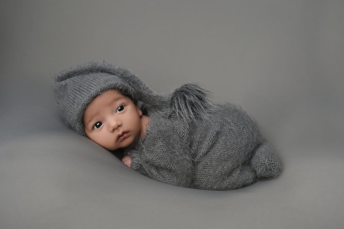 baby on a grey blanket posing for a professional photoshoot