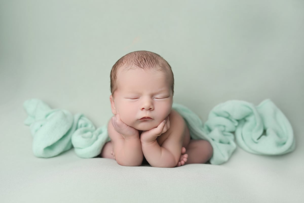 baby posing on green background for a bay art studios photoshoot