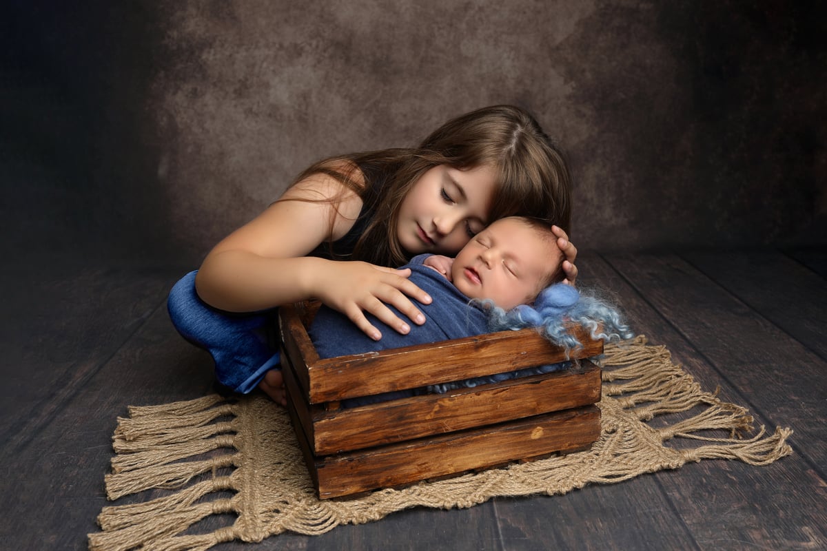 baby and older sister posing for a photo together for baby art studios