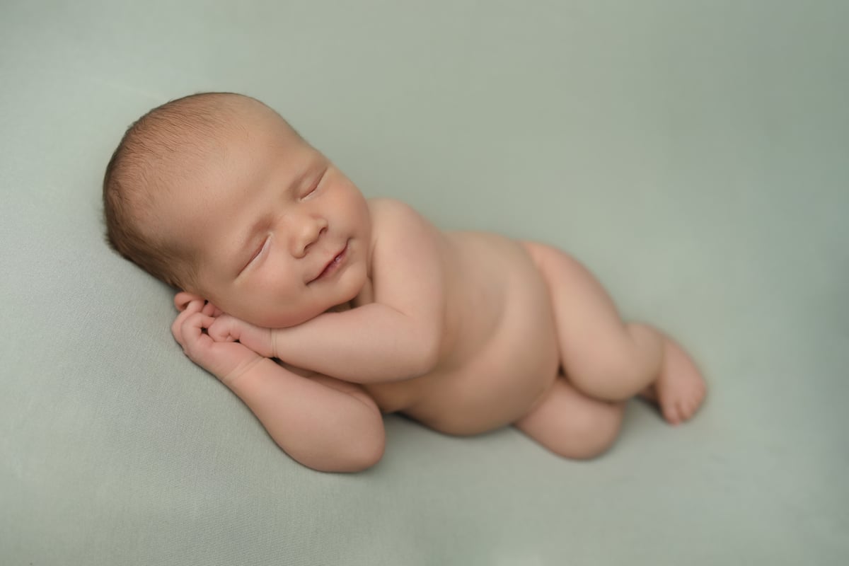 smiling new born sleeping in a professional photo