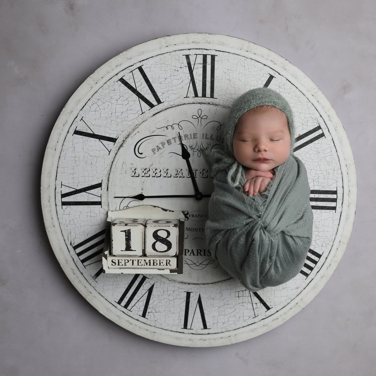 baby on clock with date of birth for baby art studios bedfordshire