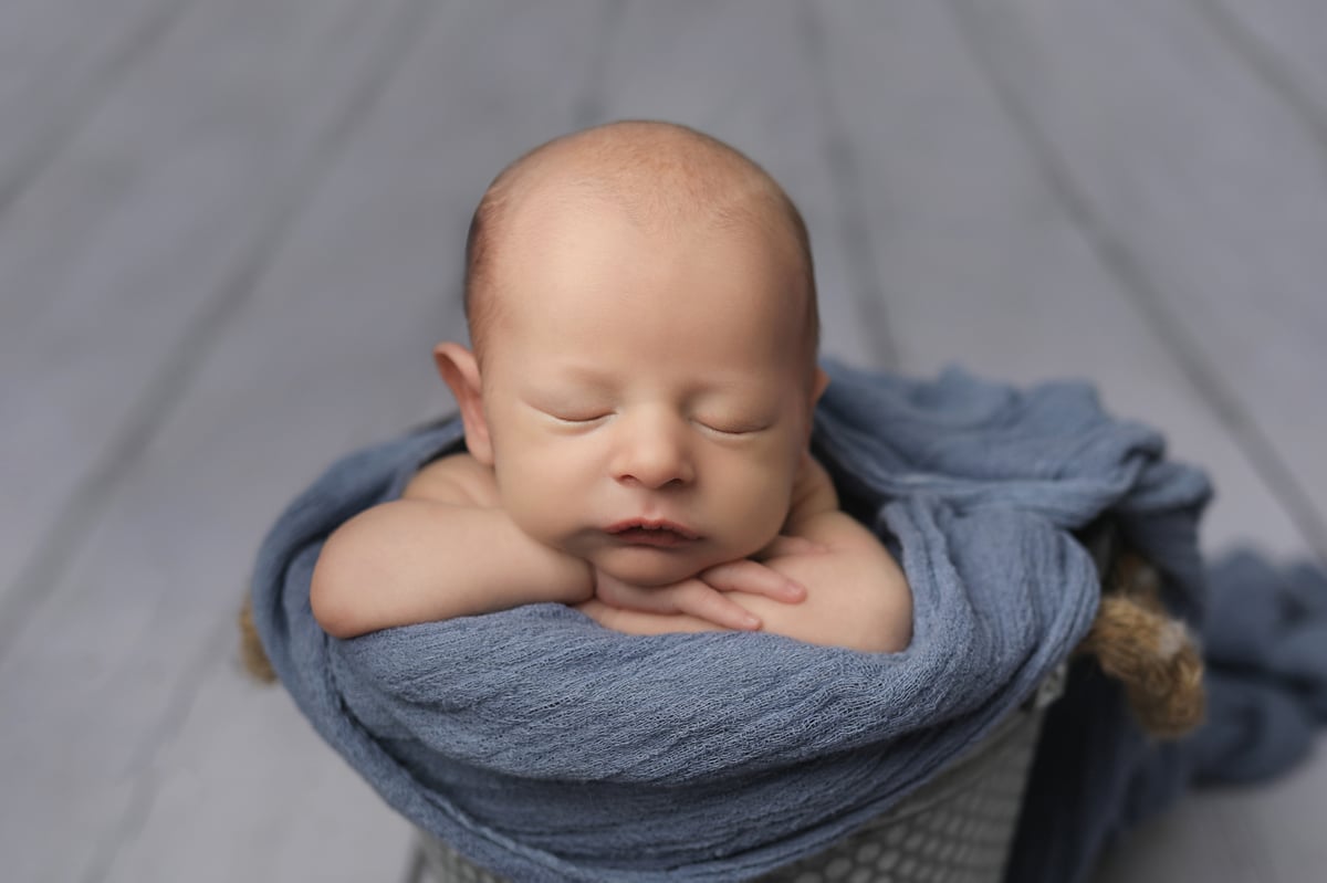 baby resting in blue blanket for a professional photoshoot