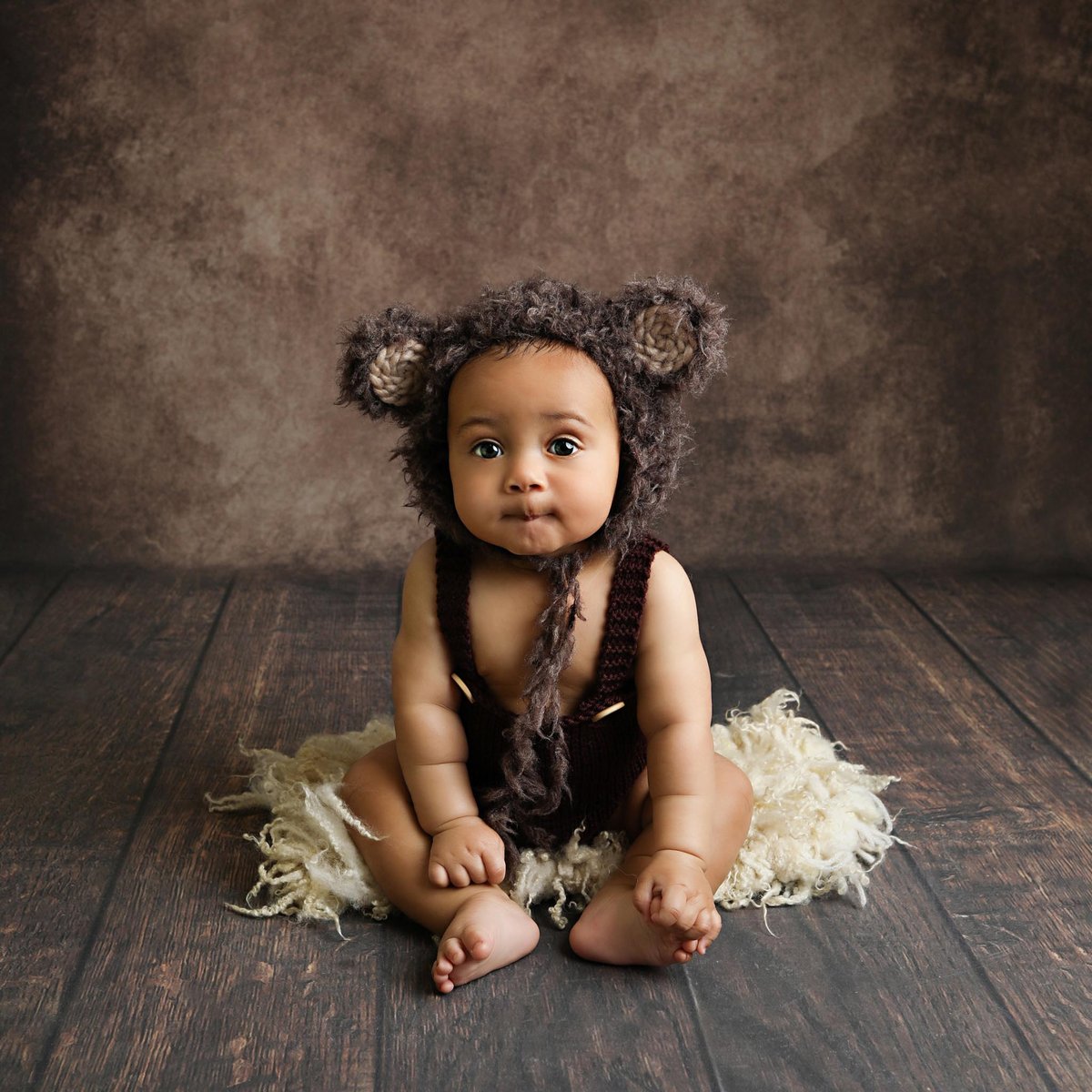 baby with cute bear ears posing for a professionally taken photograph