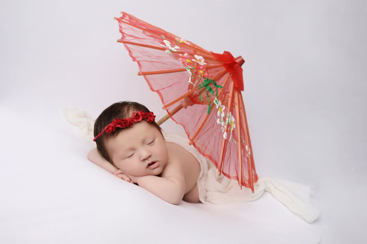 baby with umbrella posing for baby art studios