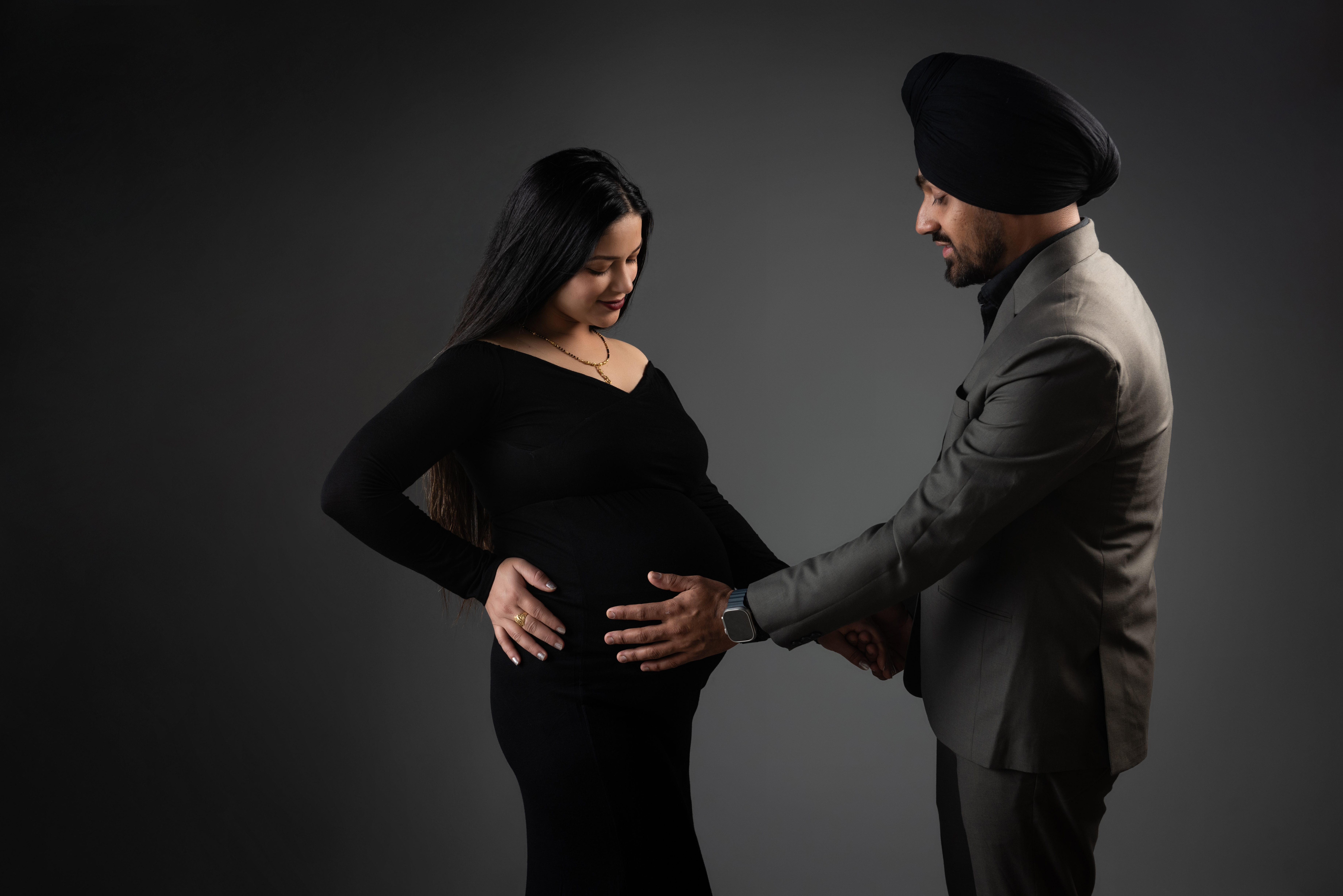 Father feeling pregnant wife's tummy, taken by photographer in Edinburgh